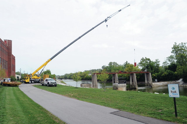 Workers from the City of Piqua and J-Crane re-install metal side panels in the dam on Great Miami River