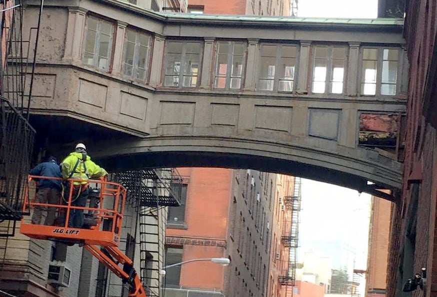 A United Rentals JLG 450AJ articulating boom lift inspecting Tribeca’s Historic Staple Street Skybridge