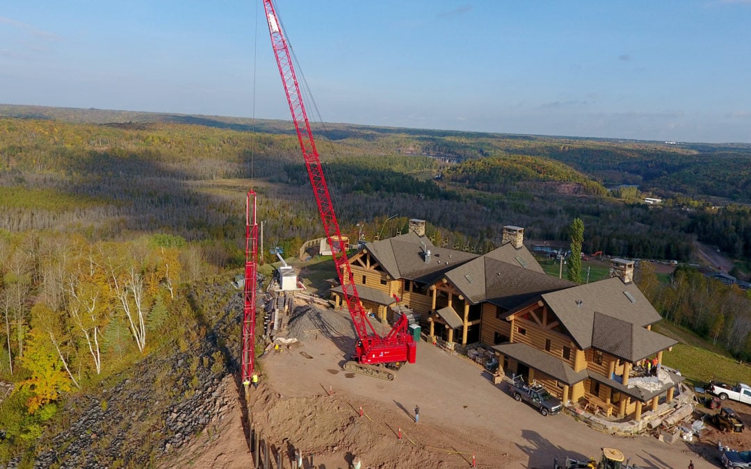 Manitowoc 11000-1 crawler crane scales Wisconsin ski hill to build retaining wall